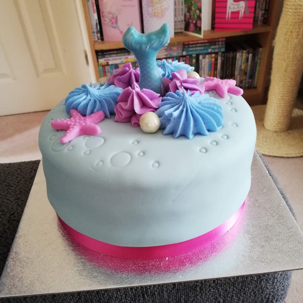 My Mermaid Birthday Cake - it's covered in pale blue icing with purple starfish decorations and edible pearls.